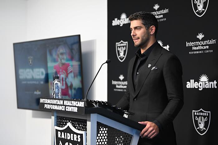 New Las Vegas Raiders quarterback Jimmy Garoppolo in front of a Raiders backdrop